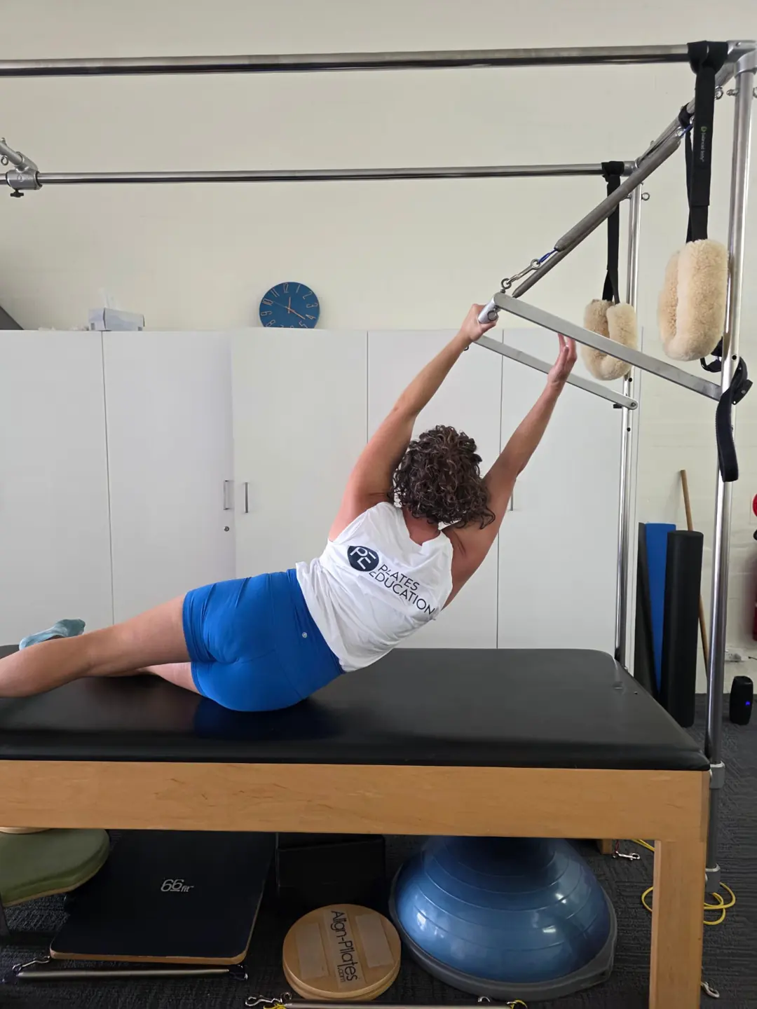 Reaching for the Cadillac push through bar, teacher training Pilates Wollongong